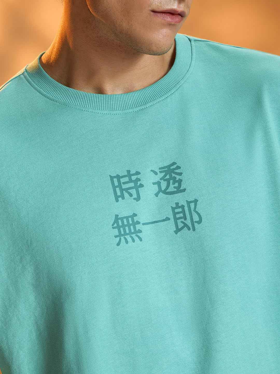 Close-up of a man wearing a light blue Demon Slayer Muichiro T-shirt with Japanese characters printed on the chest