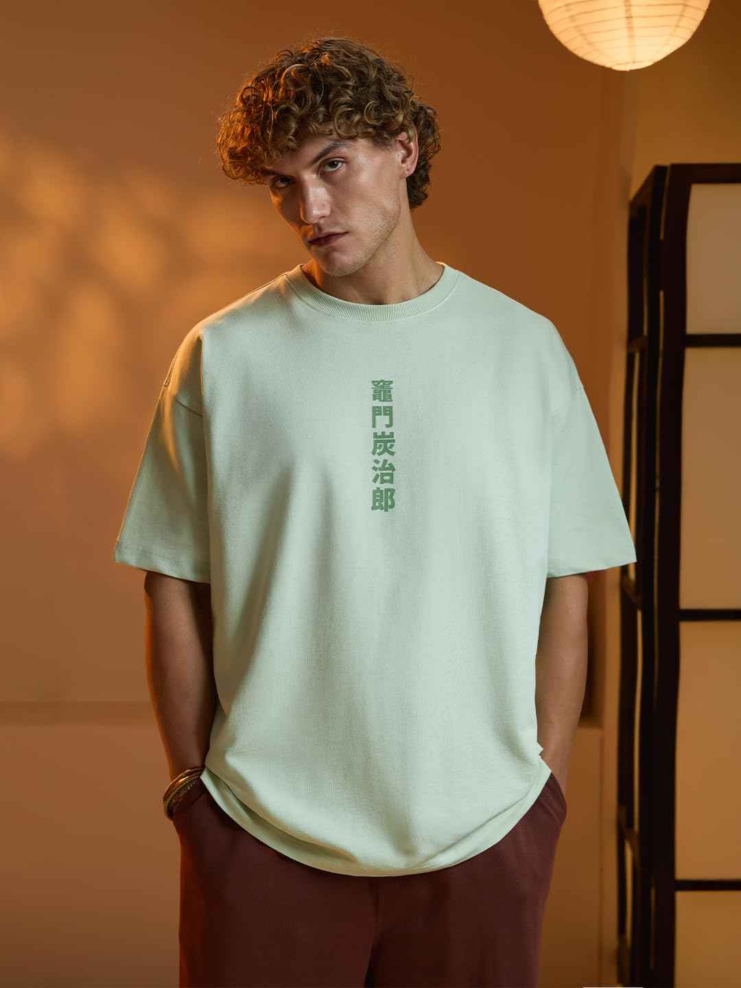 Man wearing a minimalist green Demon Slayer Tanjiro T-shirt with vertical Japanese text design