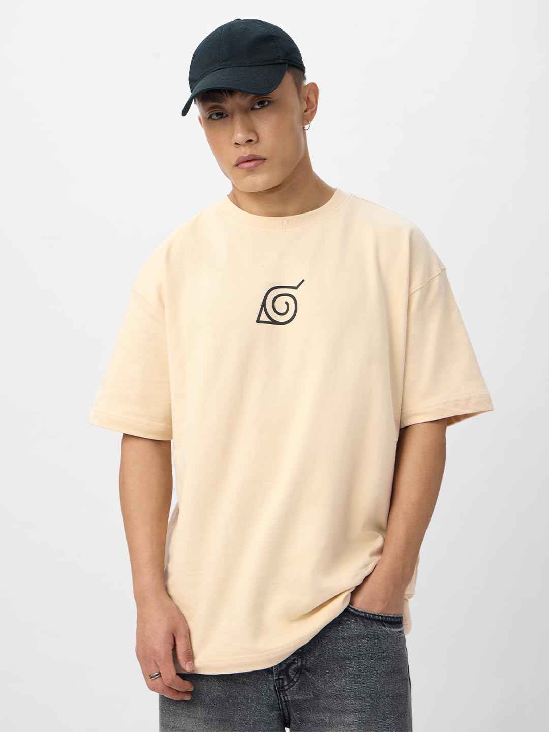 Beige Naruto Shippuden oversized t-shirt with black Leaf Village symbol worn by male model